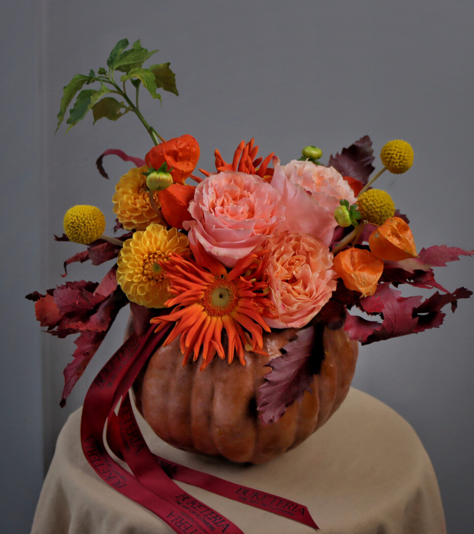 Decorative arrangement of peach garden roses and orange dahlias