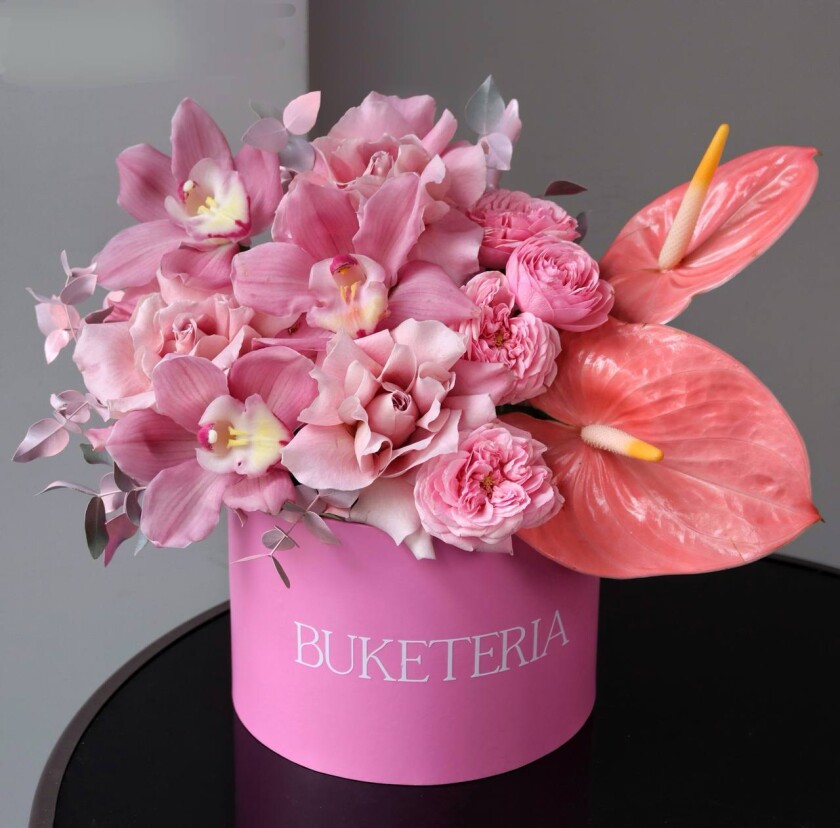 Decorative composition of blush garden roses, coral anthuriums, and pink cymbidium orchids