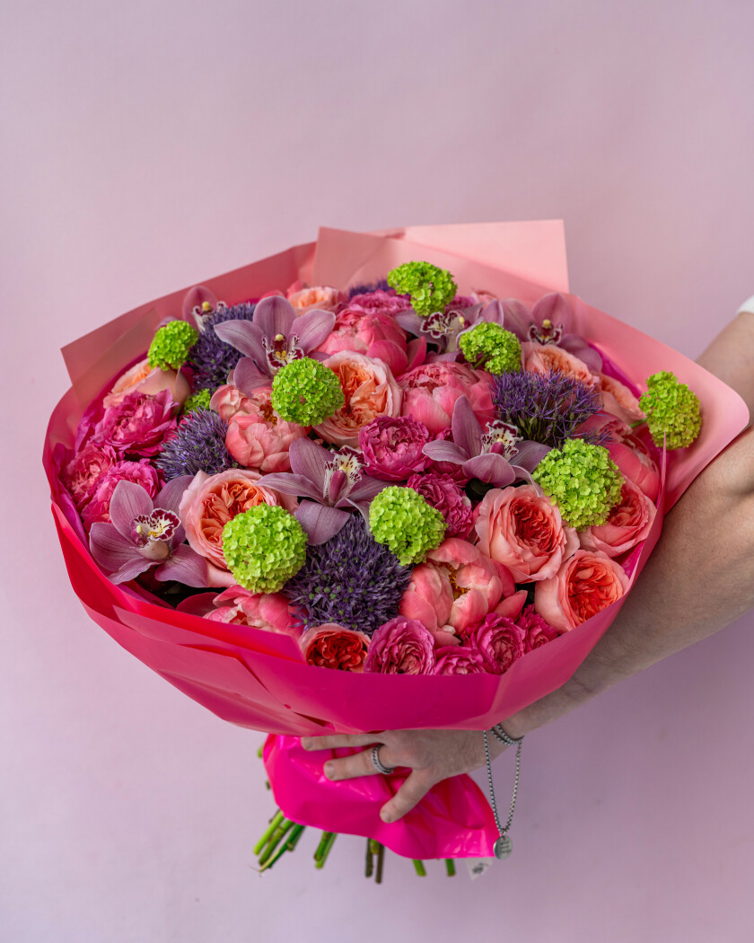 Coral peonies with peach garden roses and lavender cymbidium orchids