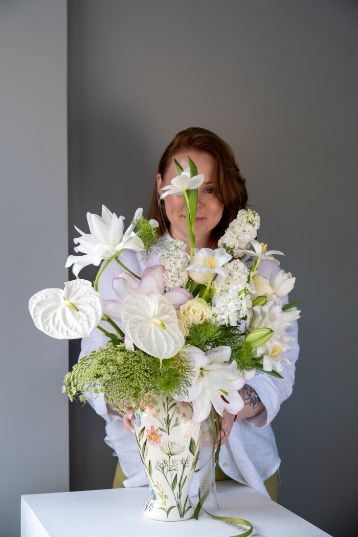 Five cream garden roses with white anthuriums and light pink tulips