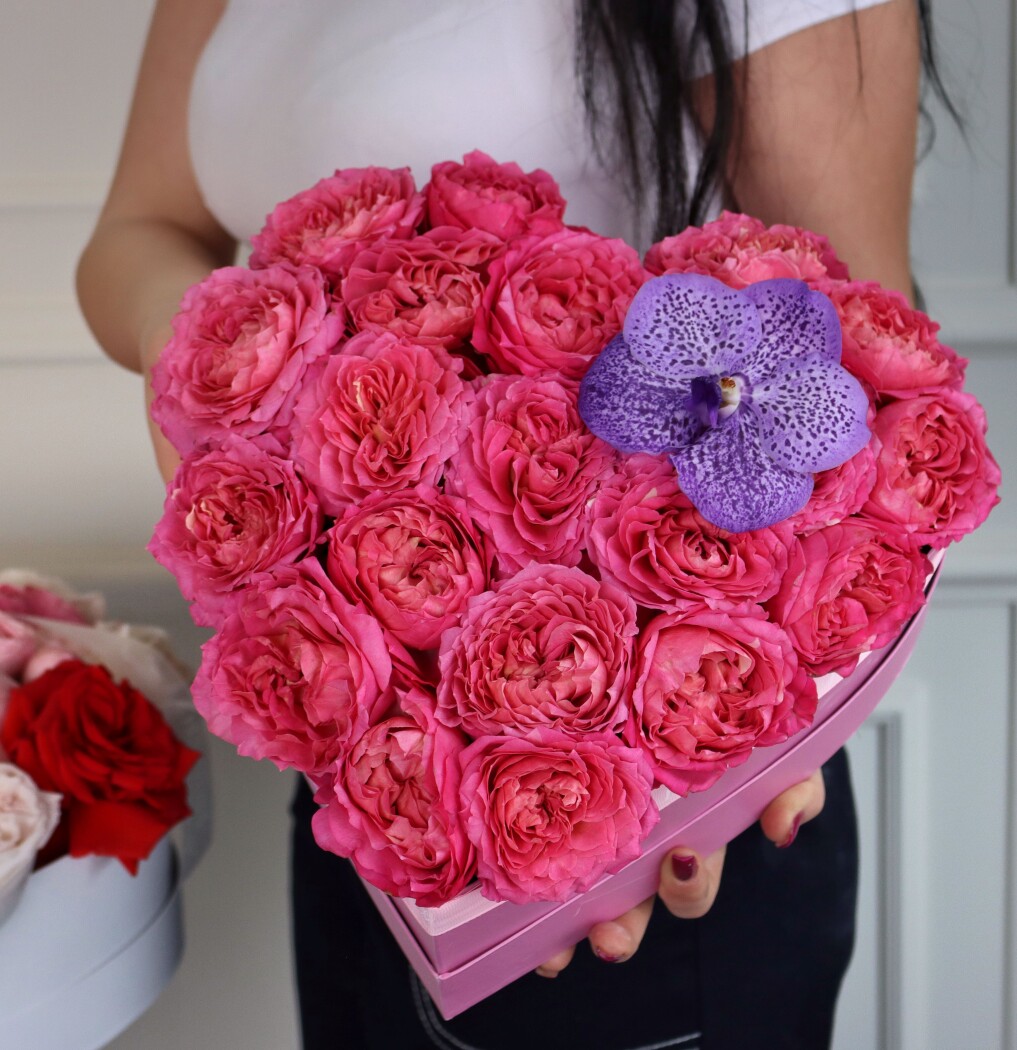 Decorative composition of hot pink spray roses and a purple vanda orchid