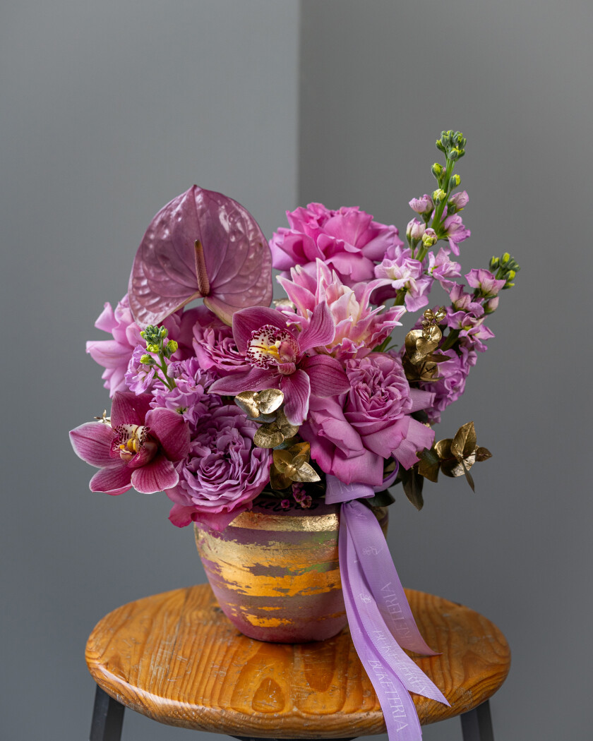 Decorative arrangement of dusty pink garden roses and purple anthurium