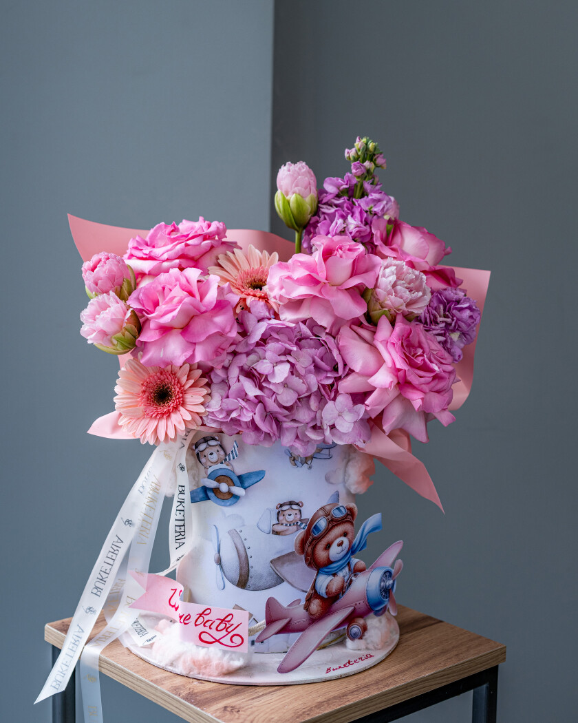 Decorative composition of pink tulips and blush garden roses in an art box