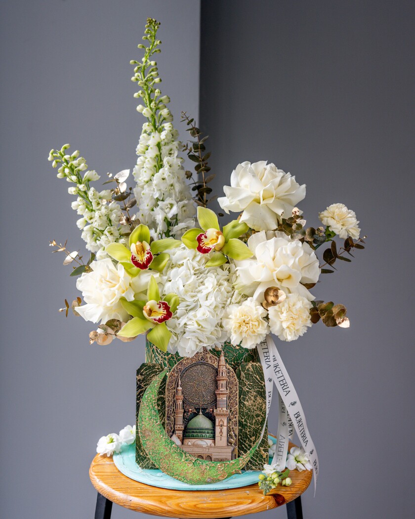 Decorative composition of white delphiniums and blush roses