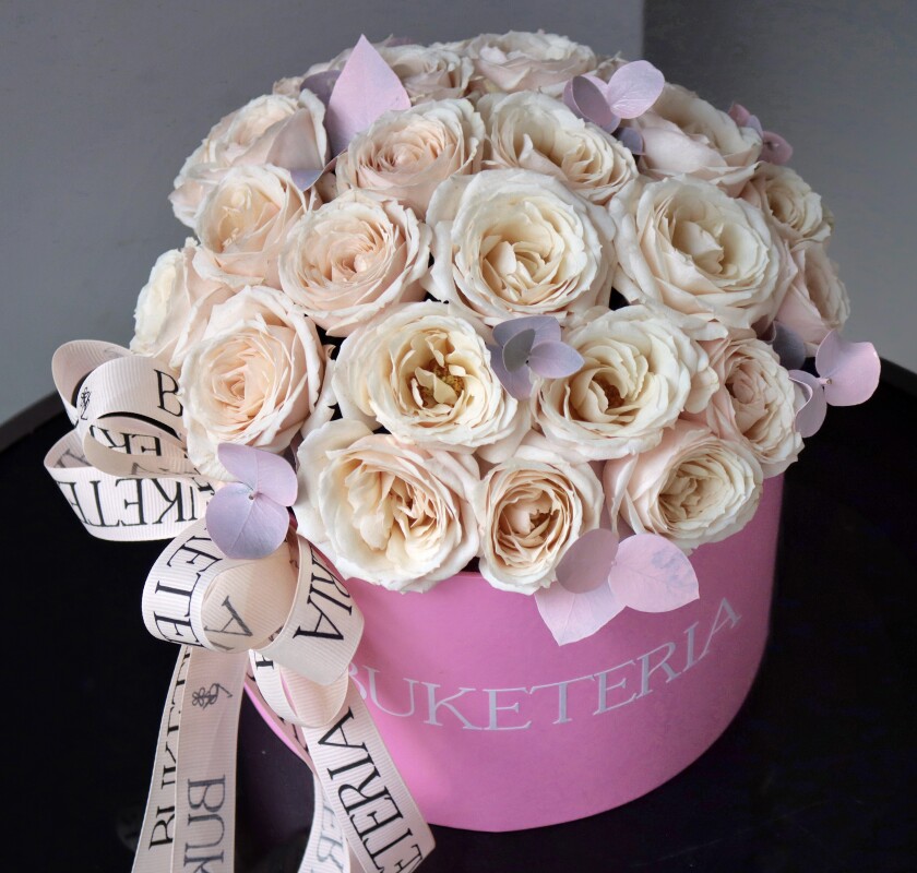Decorative composition of cream spray roses in a box