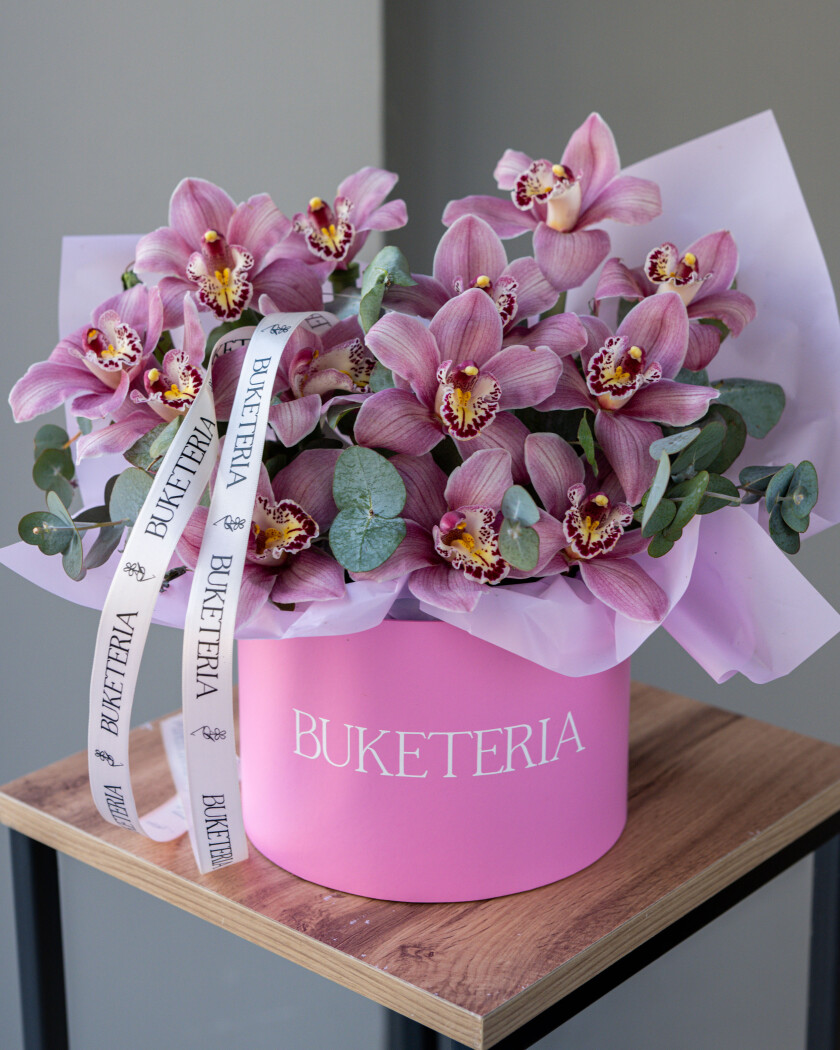 Decorative composition of pink cymbidium orchids in a luxury box