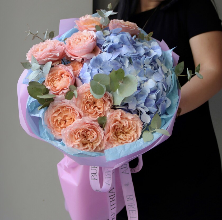 Three peach spray roses and one light blue hydrangea