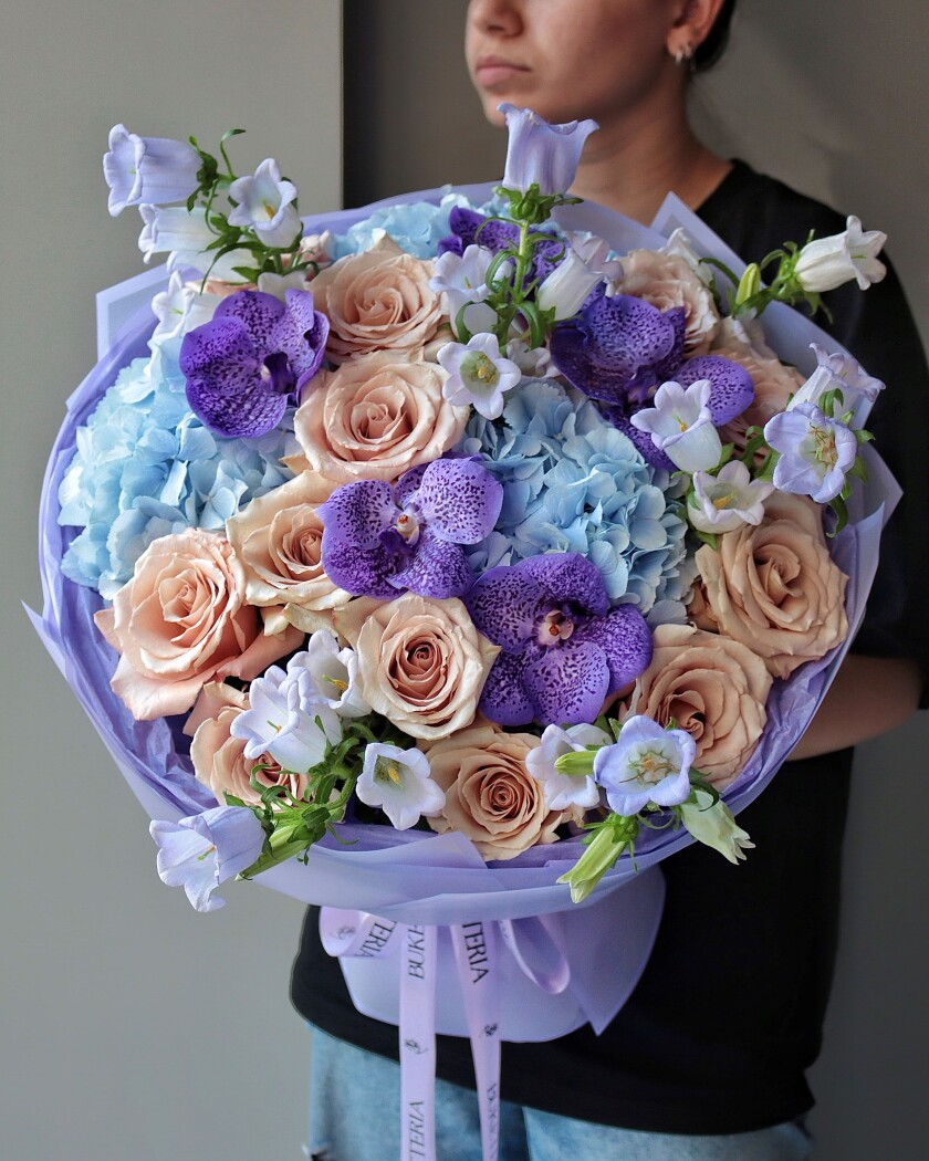 Apricot garden roses with blue hydrangeas and purple orchids