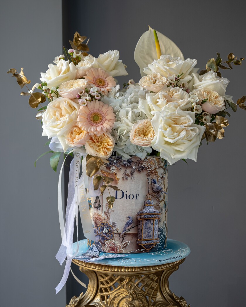 Decorative composition of cream garden roses and dusty pink spray roses
