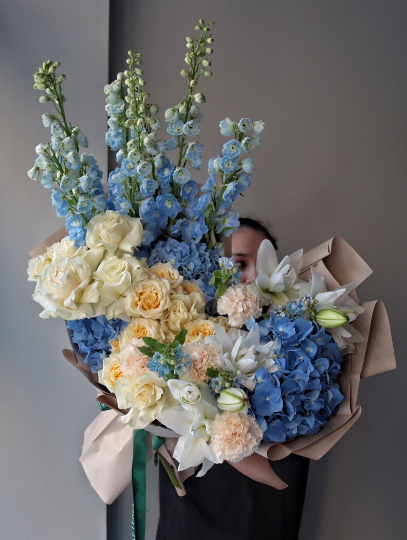 Light blue delphiniums with cream garden roses