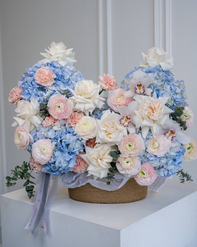 Light blue hydrangeas with blush ranunculus and peach garden roses