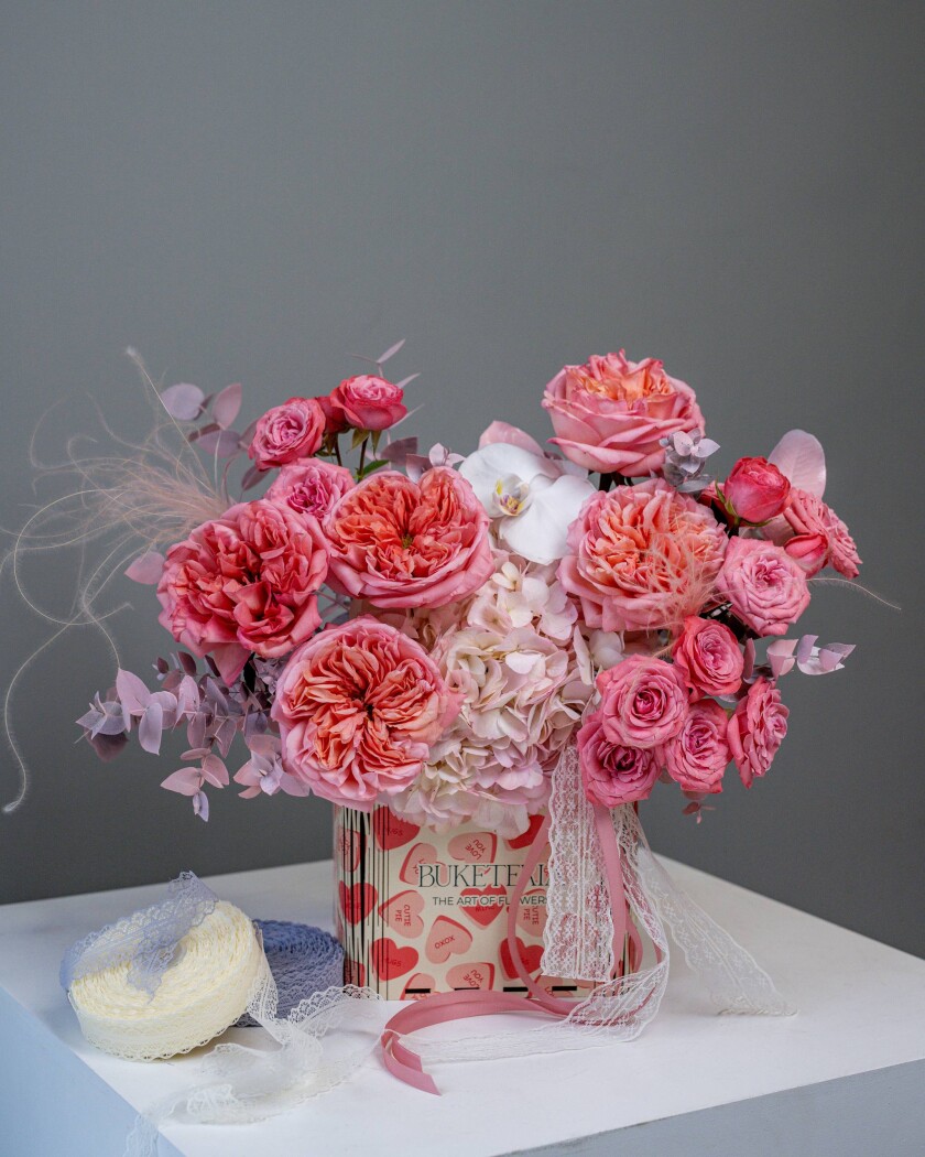 Decorative composition of dusty pink garden roses with hydrangea and orchid