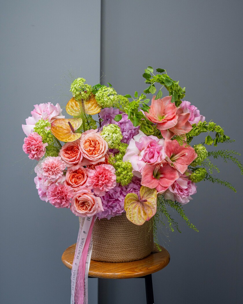 Five peach and five dusty pink garden roses with viburnum and anthurium