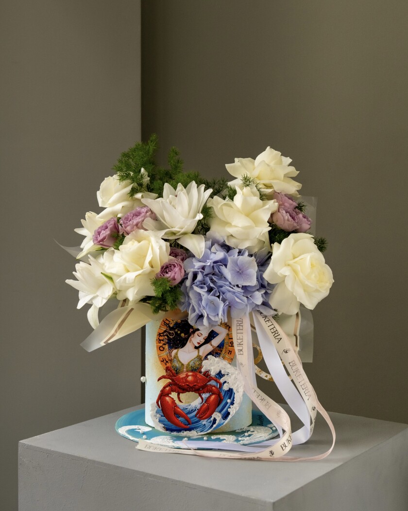 Decorative composition of cream hybrid tea roses and lavender spray roses