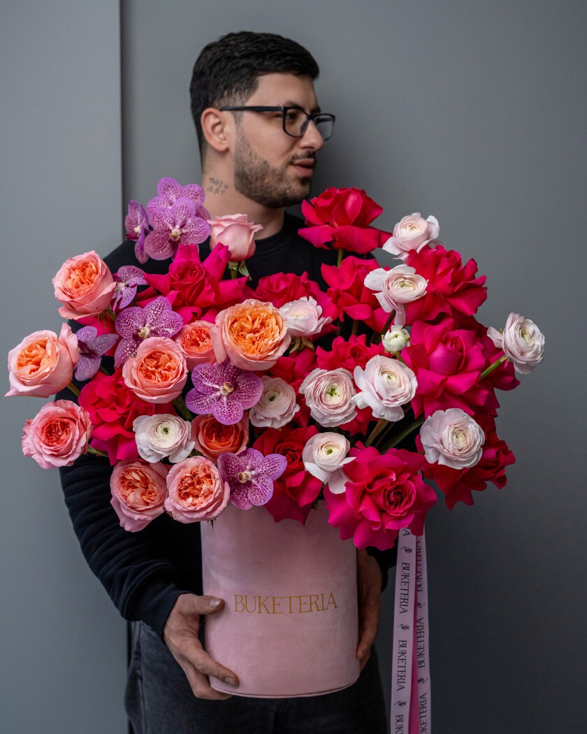 Decorative composition of deep pink and peach garden roses with purple orchids