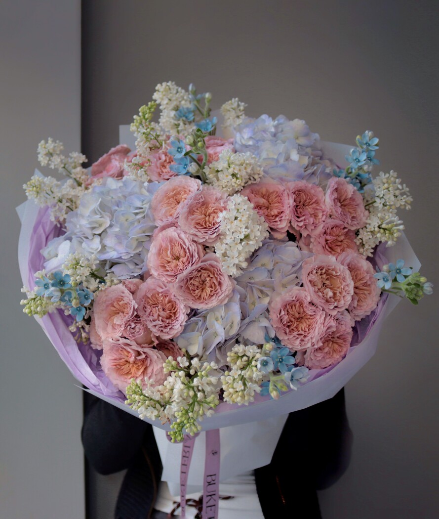 Peach spray roses with light blue hydrangeas and blue tweedia
