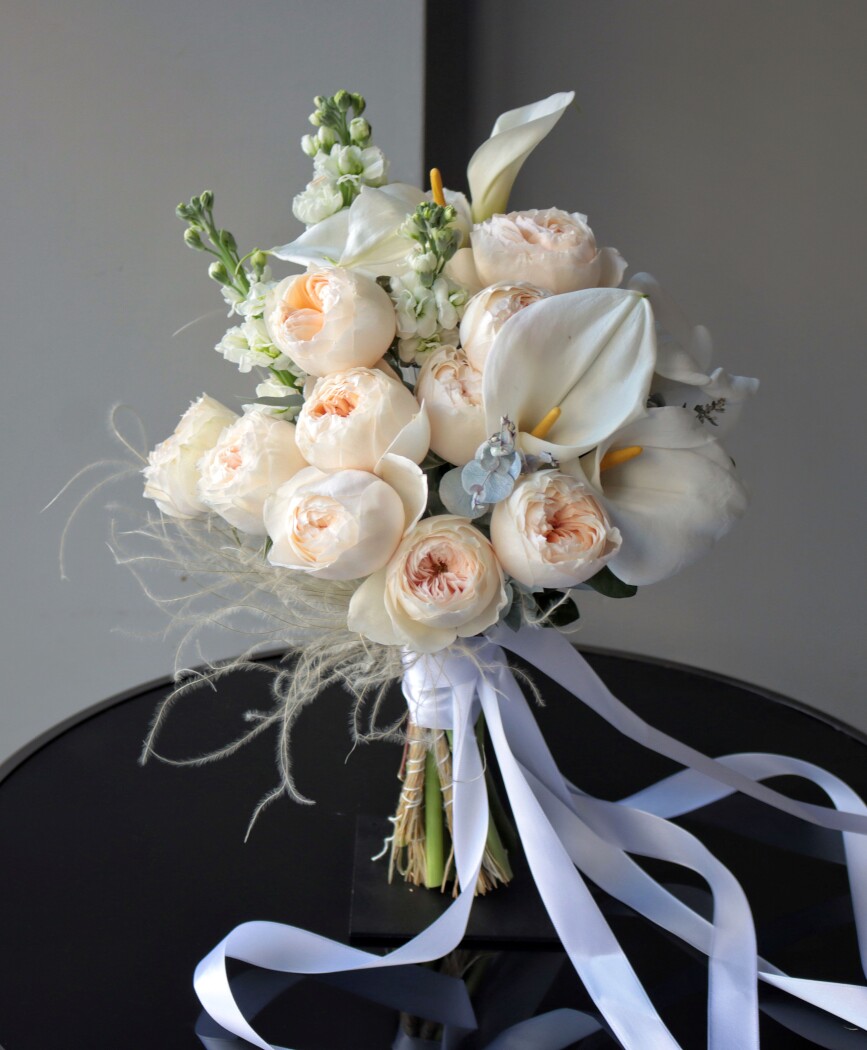 Cream callas with peach spray roses and white stock