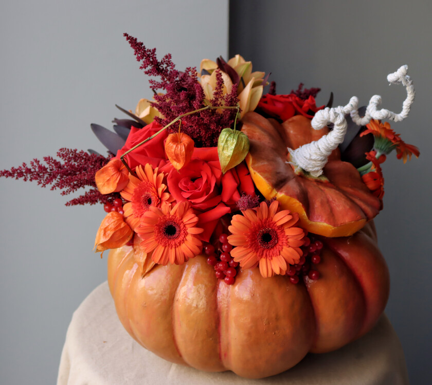 Composition of red hybrid tea roses and orange gerberas