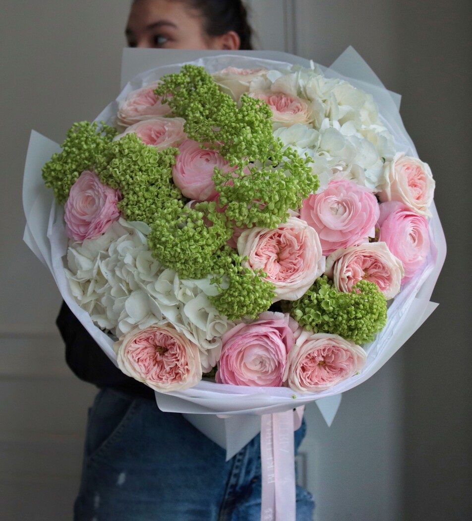 Peach garden roses with blush ranunculus and green viburnum