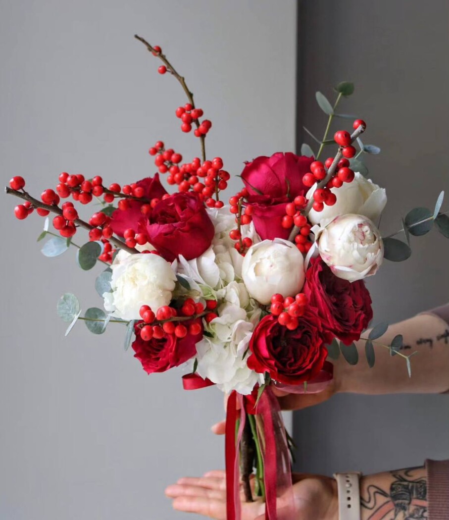 Mixed bouquet of white peonies and red hybrid tea roses