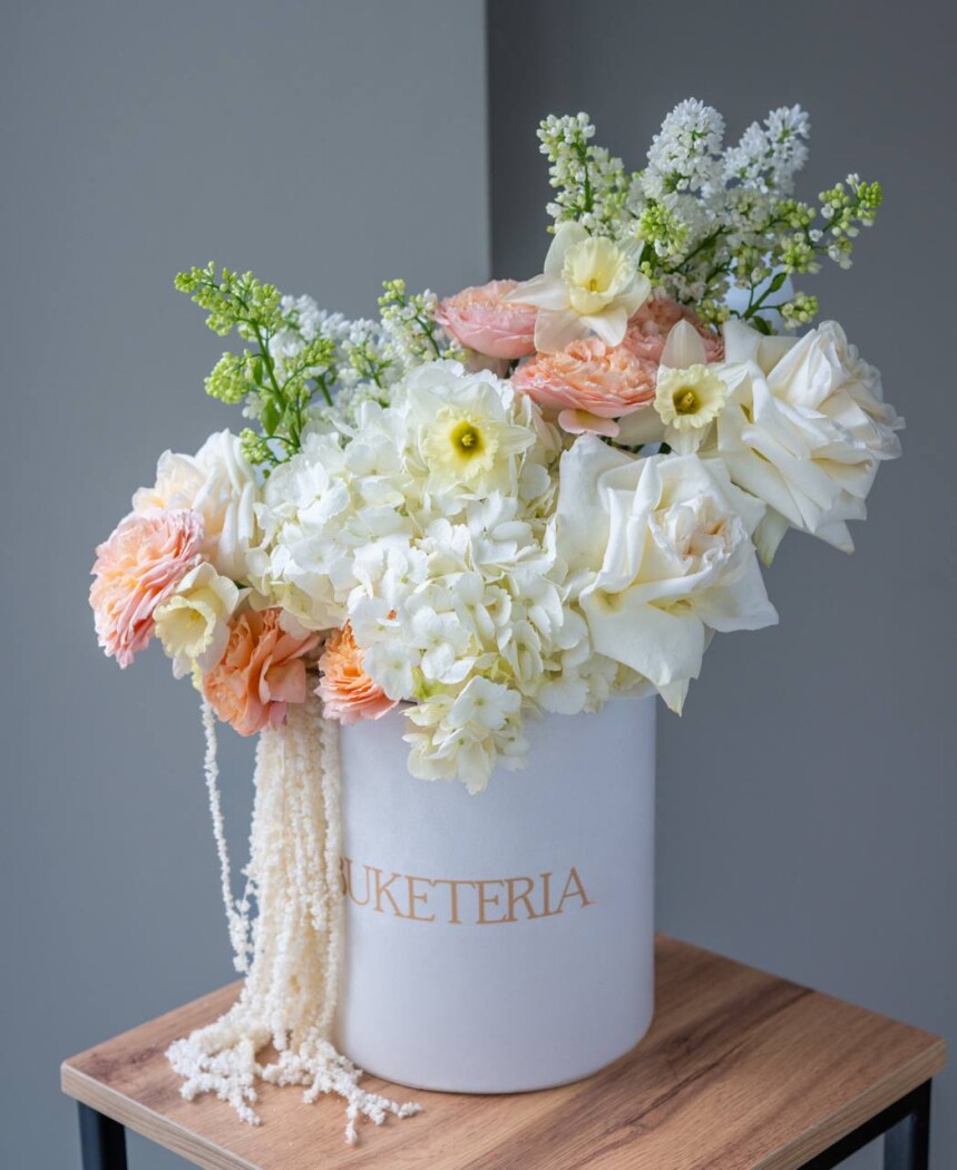 Decorative composition of light pink lilacs and peach garden roses