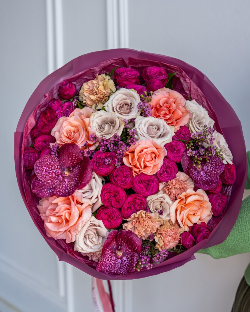Peach garden roses with hot pink spray roses and vanda orchids