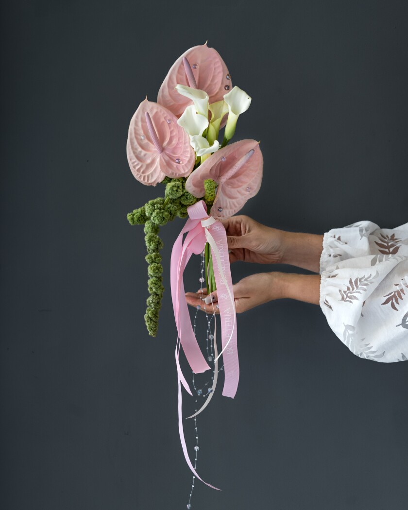 Three pink anthuriums and five white callas