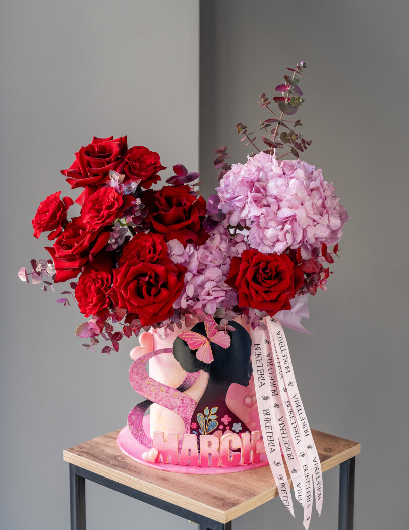 Decorative composition of light pink hydrangeas and red roses in an art box