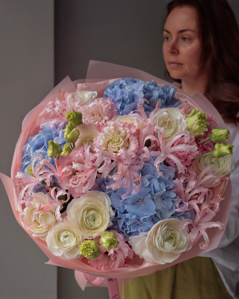 Mixed bouquet of green nerine, white ranunculus, blue hydrangea, and light pink lisianthus