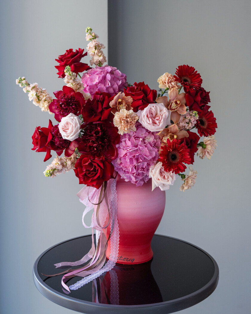 Seven red hybrid tea roses with pink hydrangeas and peonies