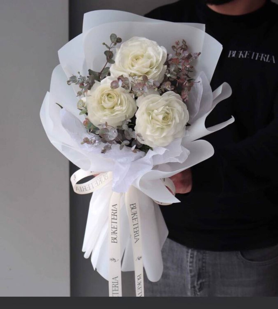 Three white ranunculus in waterproof paper