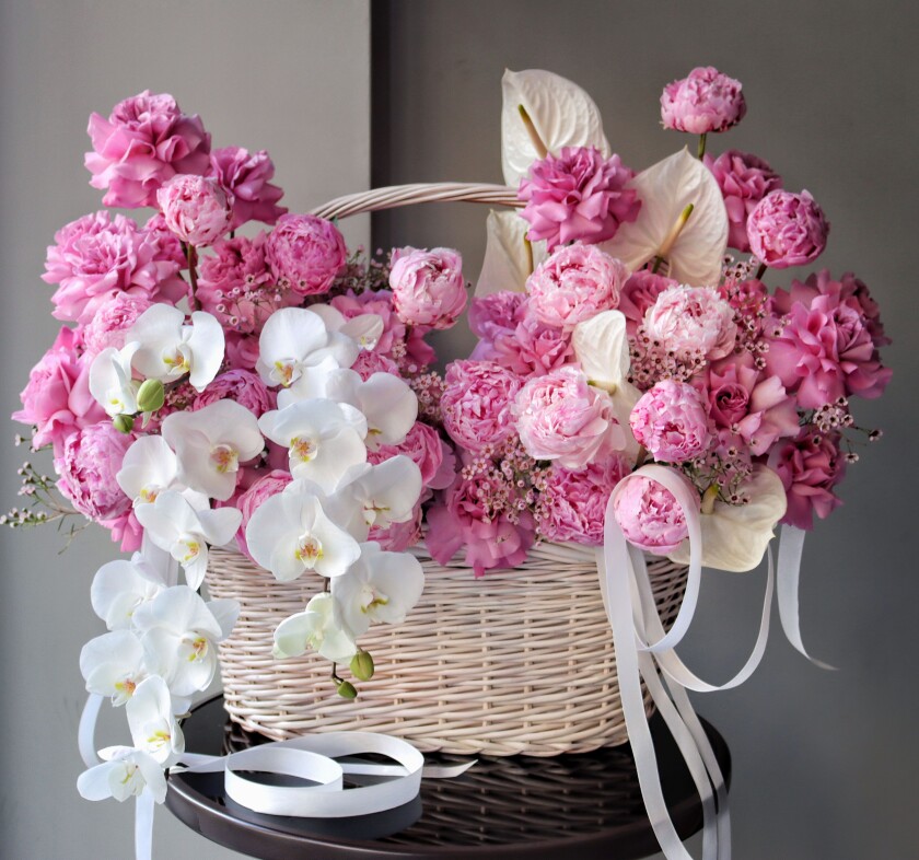 Pink peonies and blush garden roses in a basket