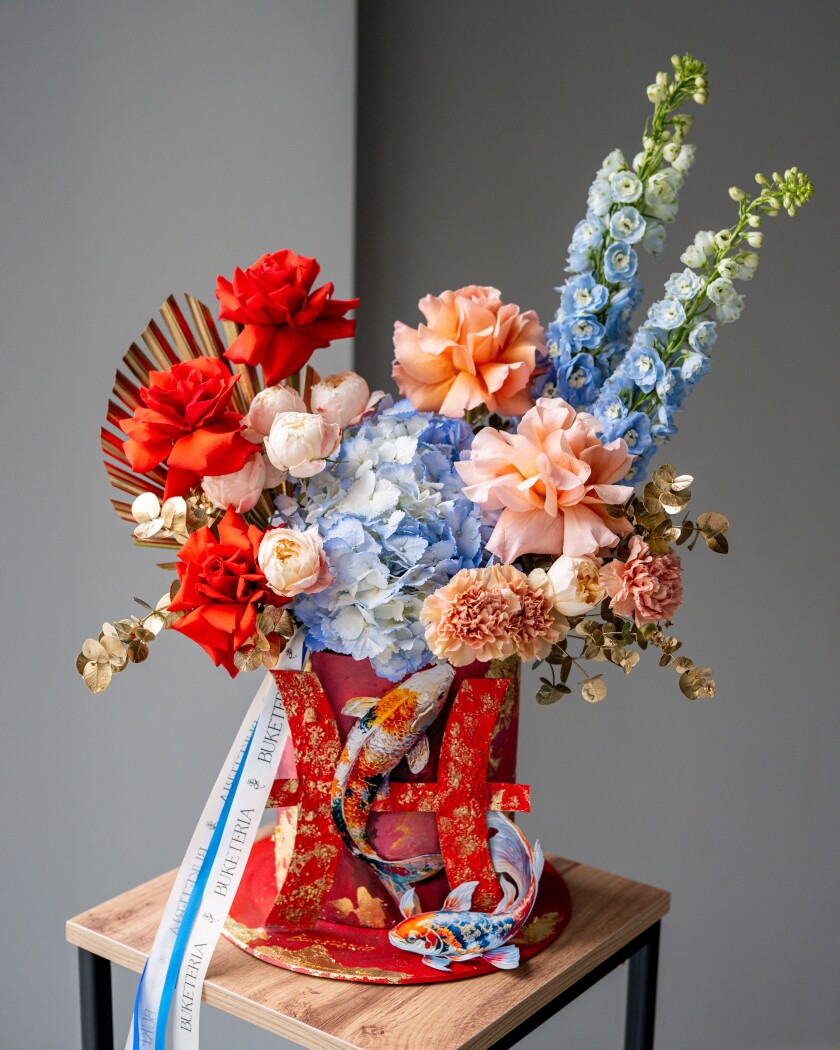 Two blue delphiniums with orange hybrid tea roses