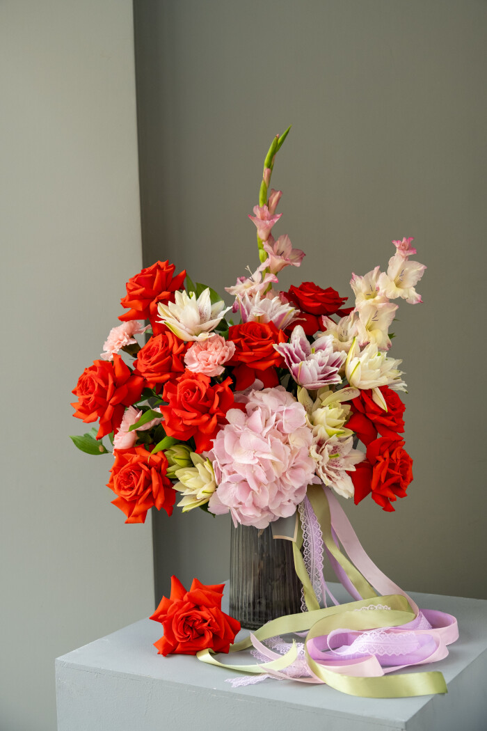 Nine red hybrid tea roses with pink hydrangea and white gladiolus