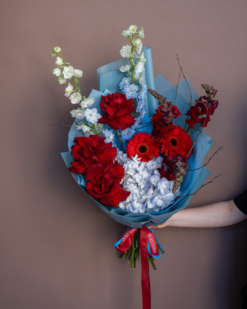 Blue delphiniums with red roses and hydrangeas