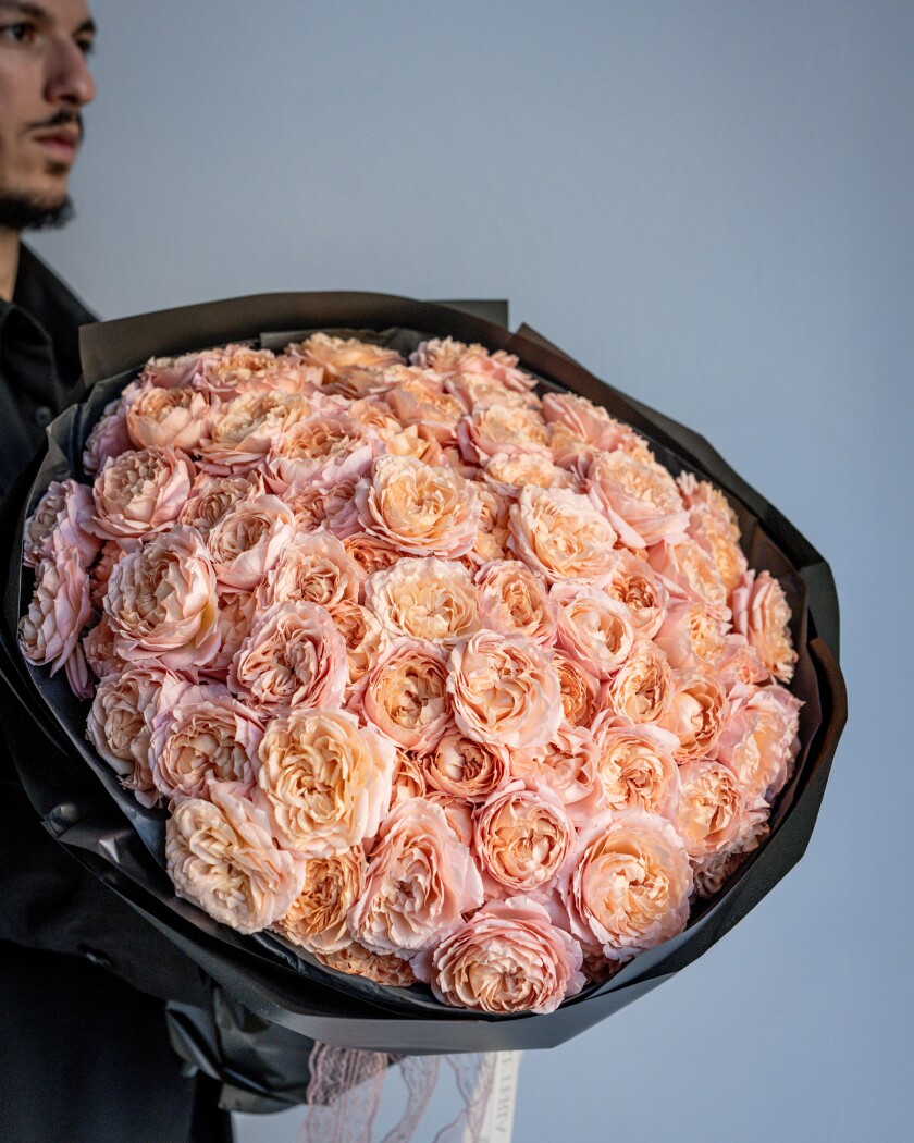 Twenty-one peach spray roses in waterproof paper