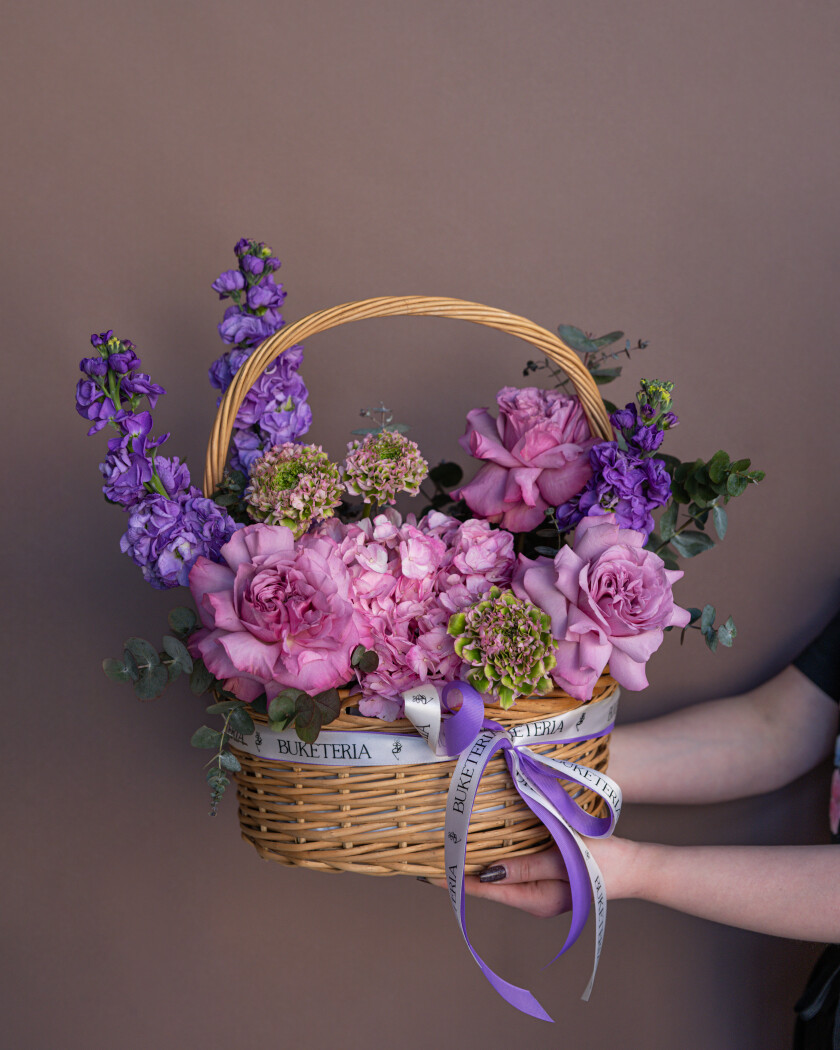 Elegant pink ranunculus and garden roses in a basket