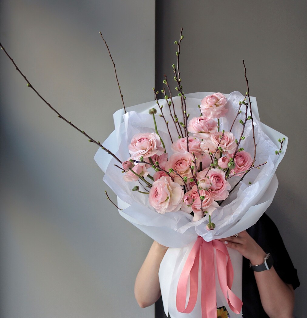 Seventeen light pink ranunculus with cherry blossom branches