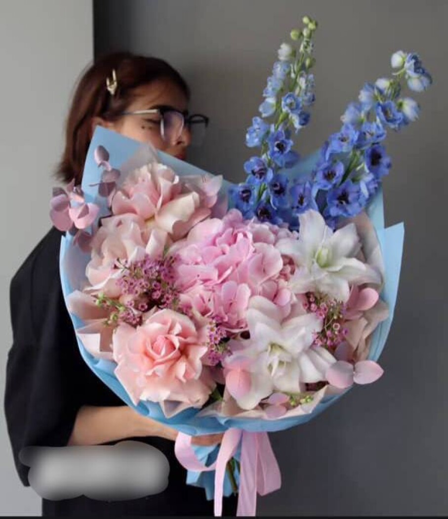 Mixed bouquet of blue delphiniums and dusty pink garden roses