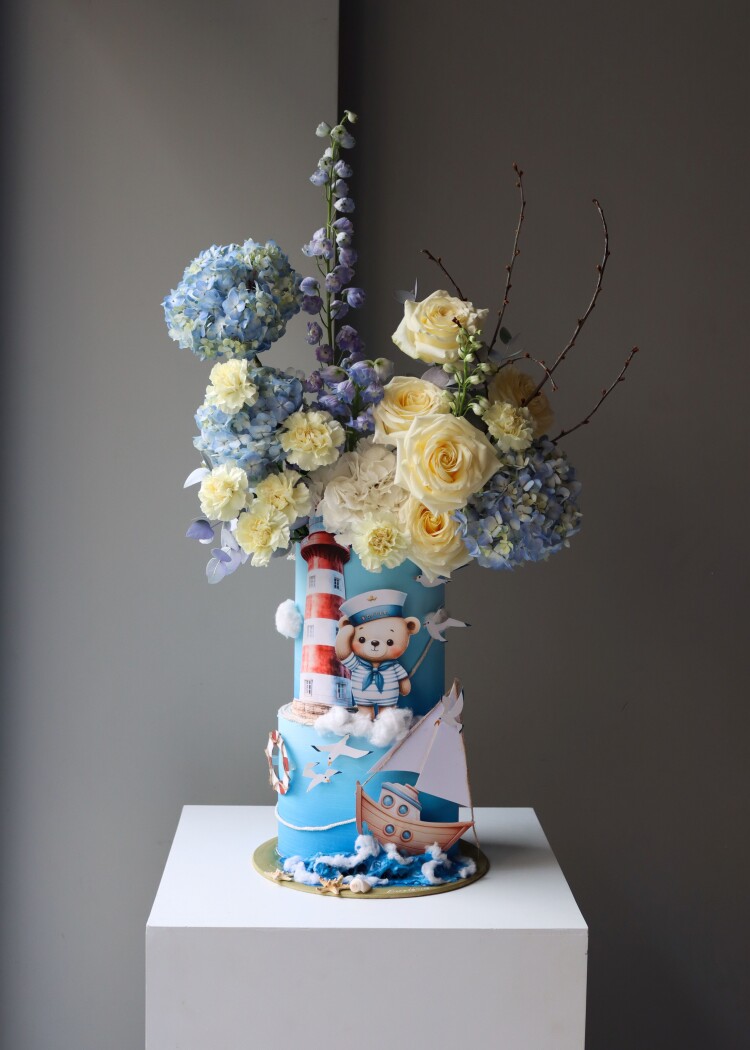 Decorative composition of light blue hydrangeas and cream roses in an art box