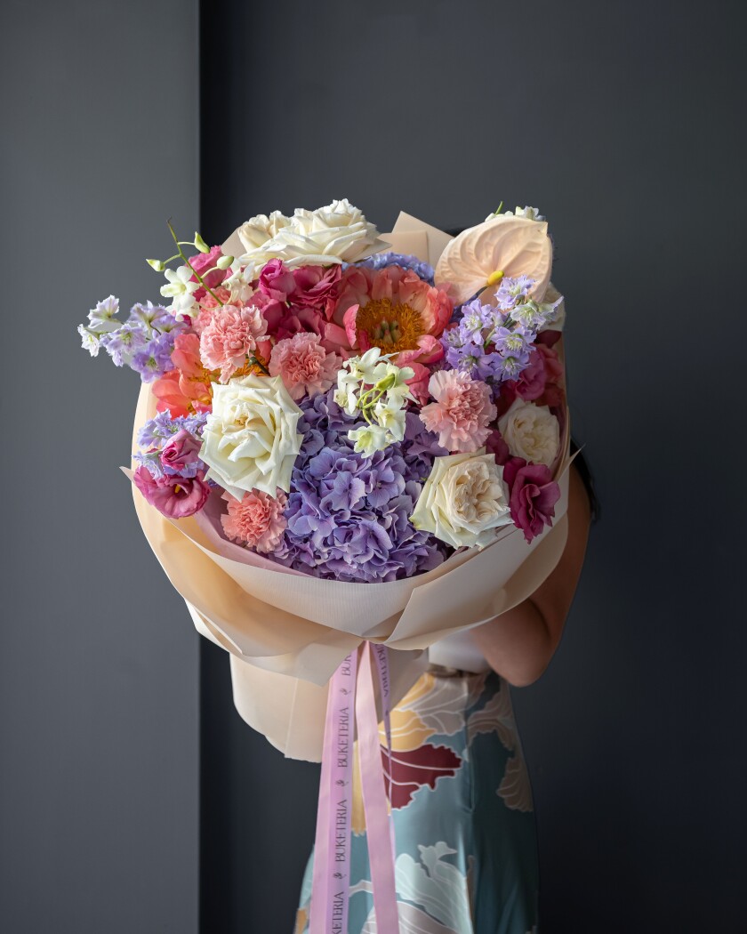 Mixed bouquet of light pink delphiniums and coral peonies