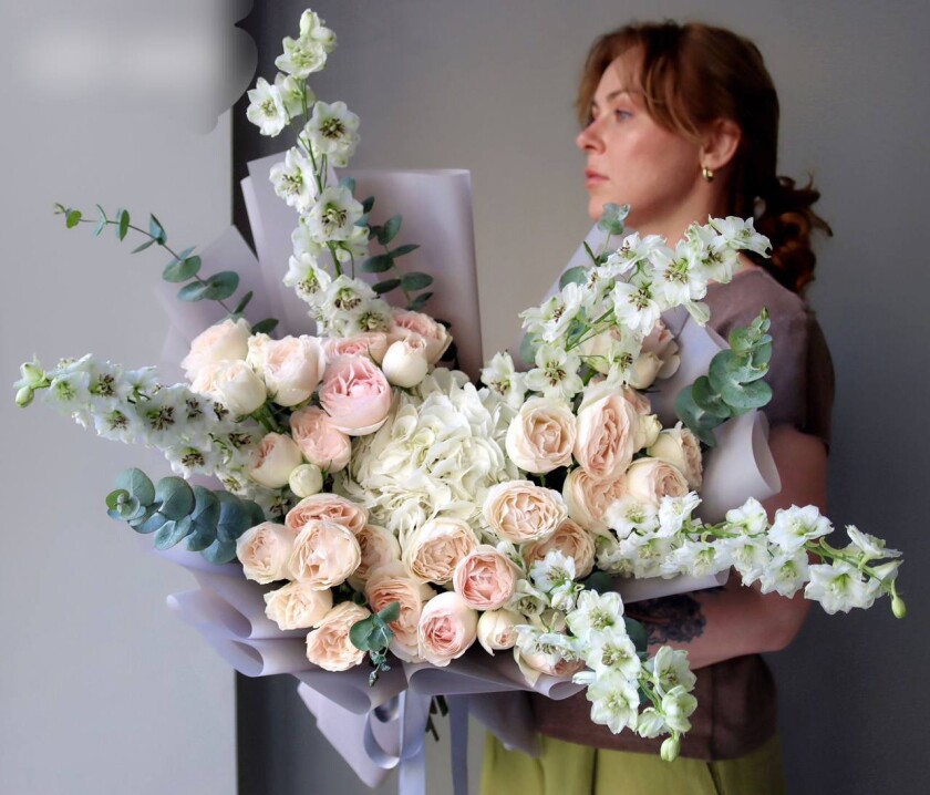 Peach spray roses with light blue delphiniums and white hydrangea