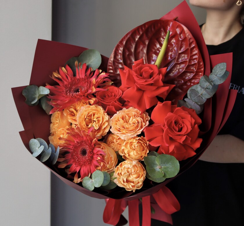 Mixed bouquet of apricot garden roses and red hybrid tea roses