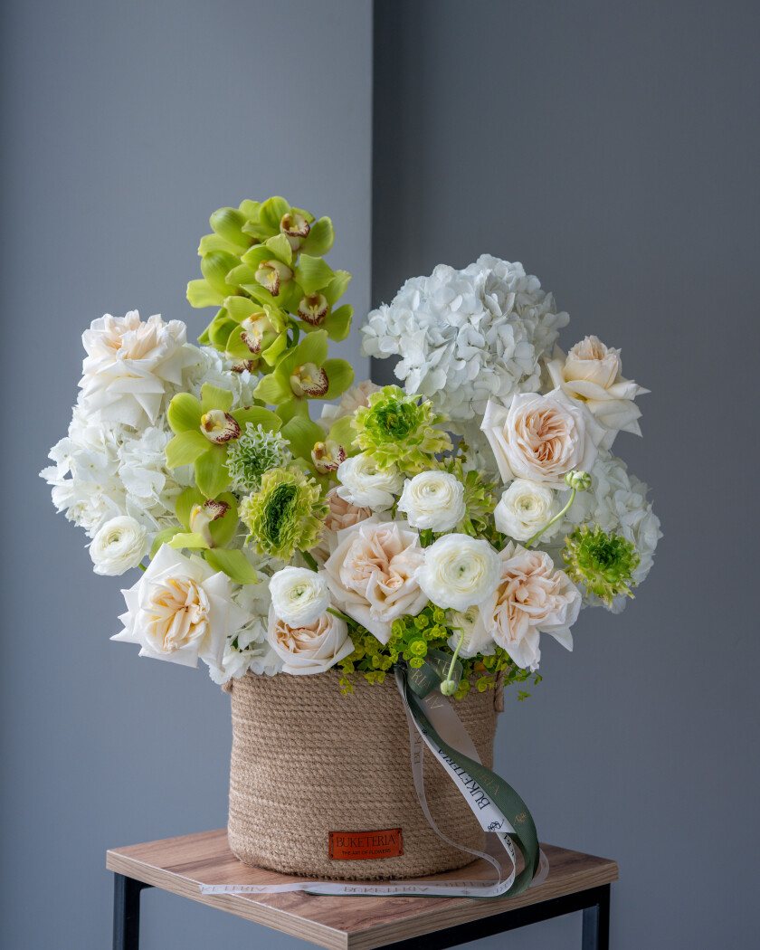 White ranunculus with cream hydrangeas and green cymbidium orchids