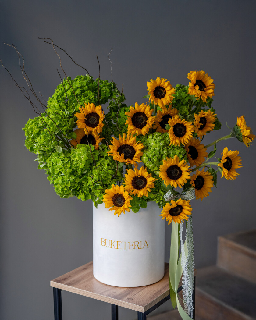 Decorative composition of orange sunflowers and green hydrangeas