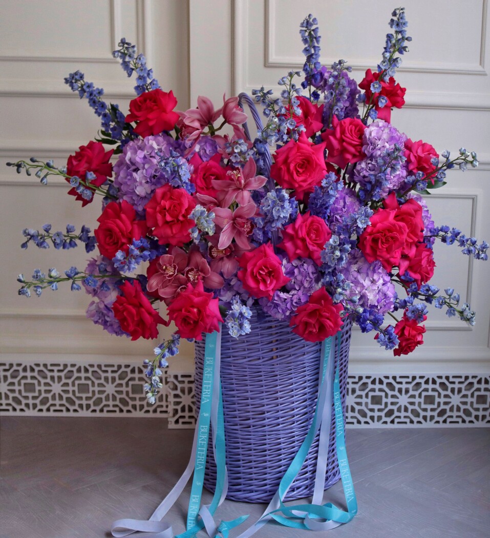 Decorative arrangement of light blue delphiniums and deep pink garden roses