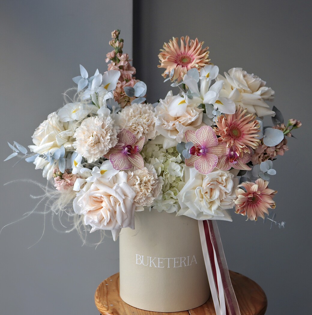 Decorative composition of cream garden roses and pink phalaenopsis orchids