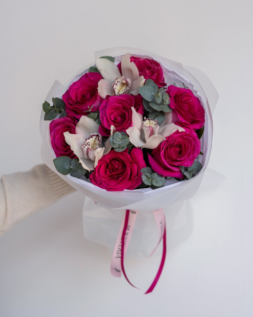 Seven hot pink garden roses with three white cymbidium orchids