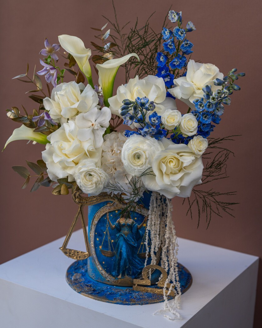 Three blue delphiniums with cream callas and roses