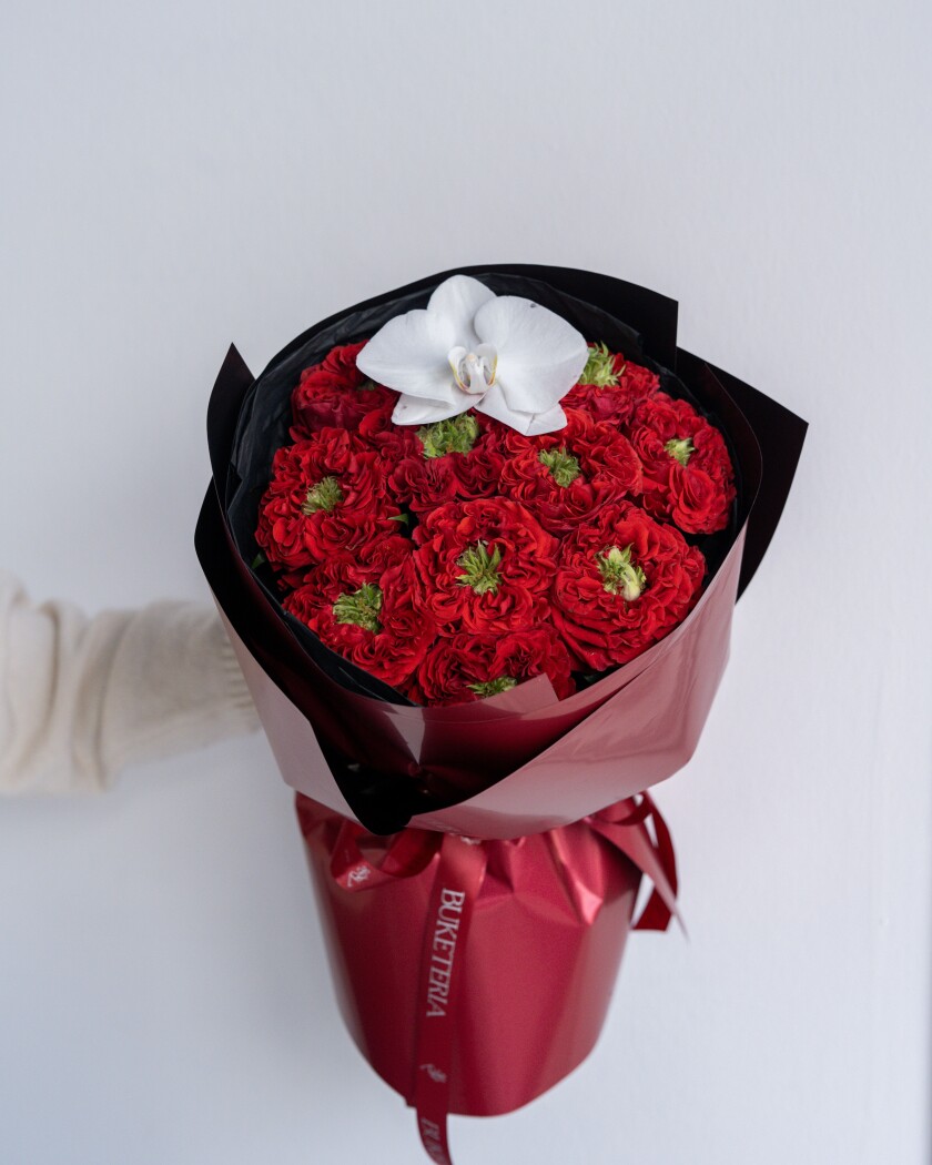 Eleven red garden roses with a white phalaenopsis orchid